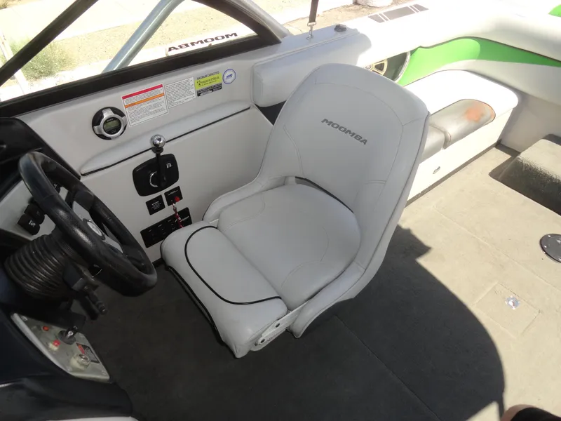 Slide: The Image of 2011 Moomba Outback V boat interior with white captain's seat and steering wheel. - 11