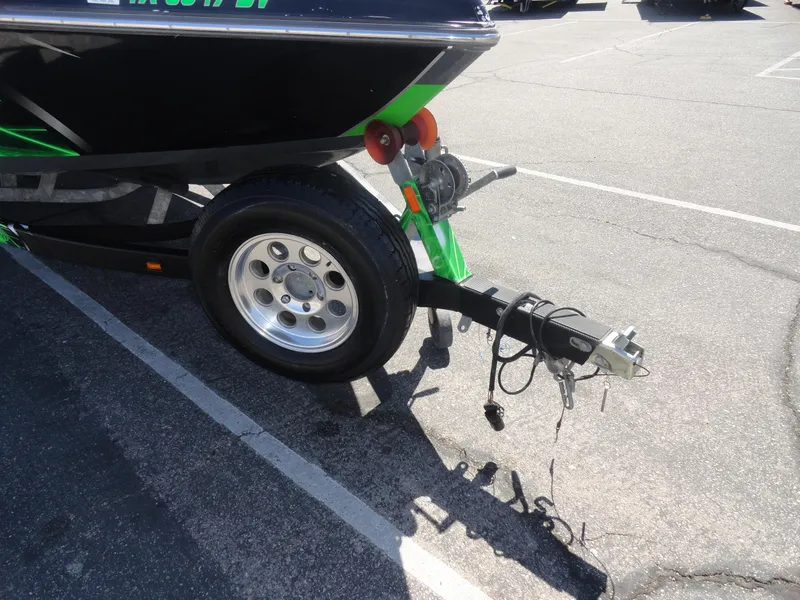 Slide: The Image of 2011 Moomba Outback V boat trailer hitch and wheel in parking lot. - 20