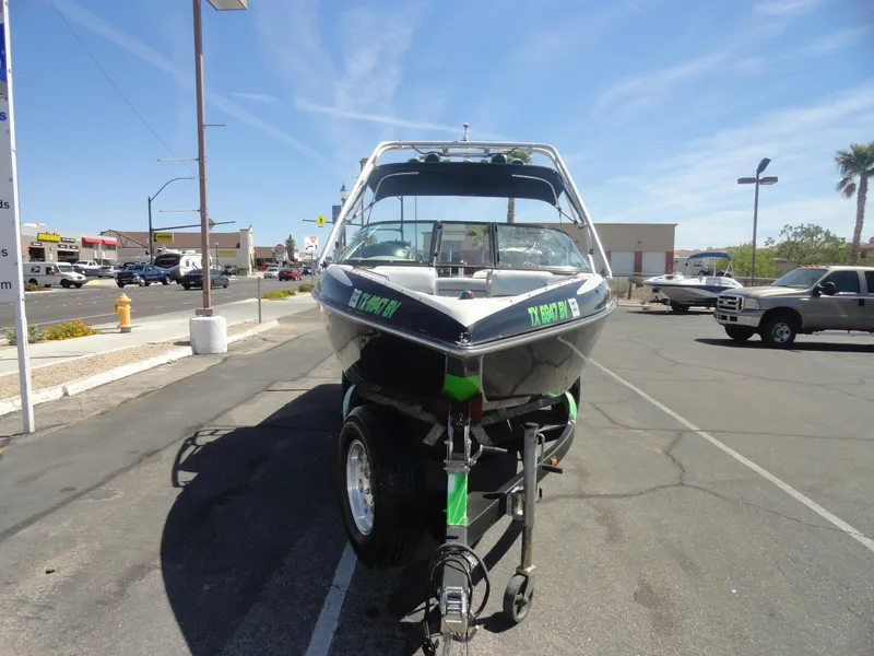 Slide: The Image of 2011 Moomba Outback V boat on trailer in parking lot under clear sky. - 3