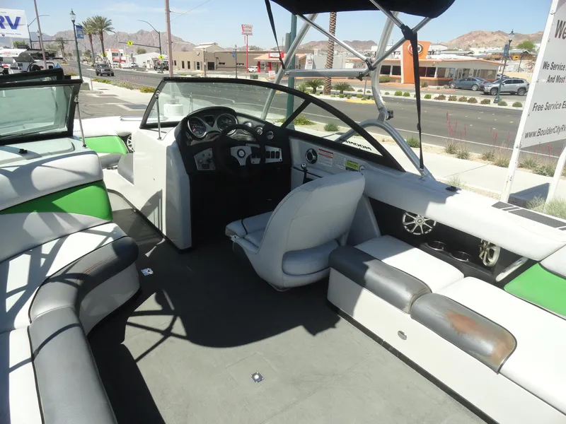 Slide: The Image of 2011 Moomba Outback V boat interior with seating and steering wheel, parked outdoors. - 7
