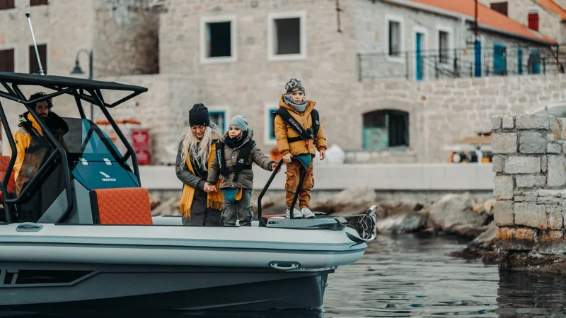 Slide: The Image of Family enjoying a day on a 2025 Highfield ADV7 boat near a stone building. - 2