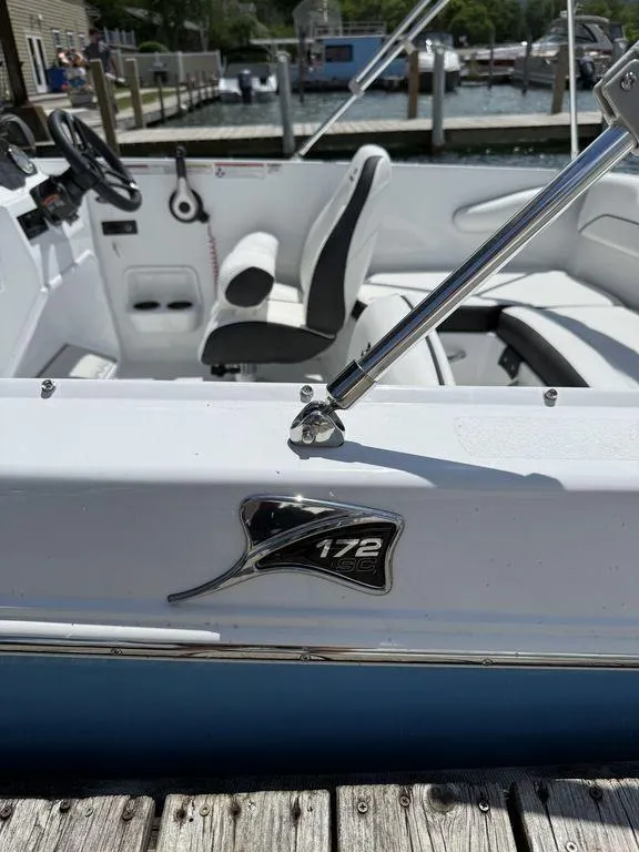 Slide: The Image of 2025 Stingray 172SC boat interior at dock, featuring sleek white seating and controls. - 10