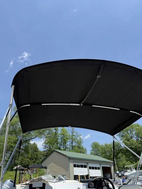 Slide: The Image of 2025 Stingray 172SC boat with black canopy under clear blue sky. - 33