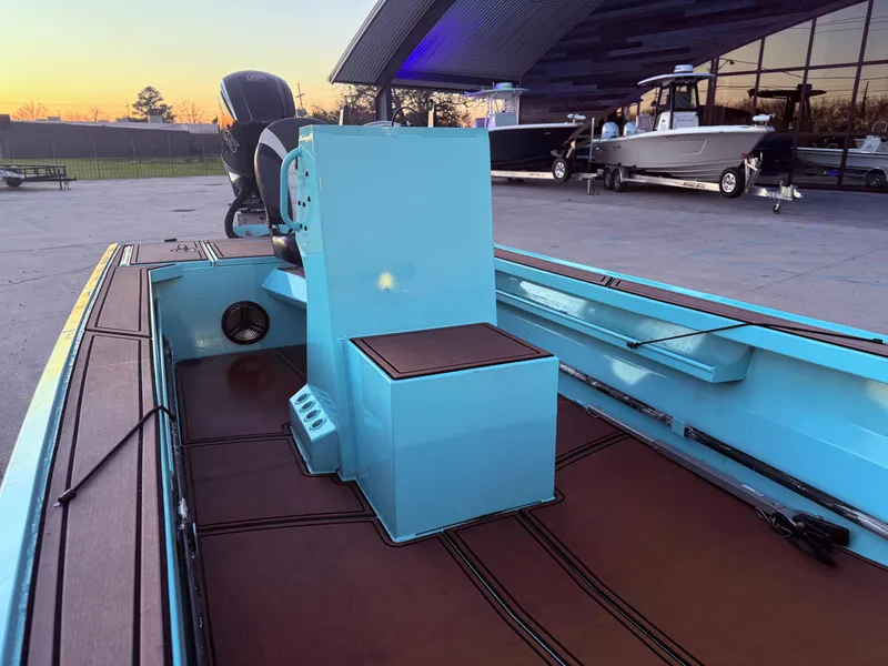 Slide: The Image of 2022 Custom Uncle J 19 Bay Center Console Aluminum boat, blue interior, docked at sunset. - 10