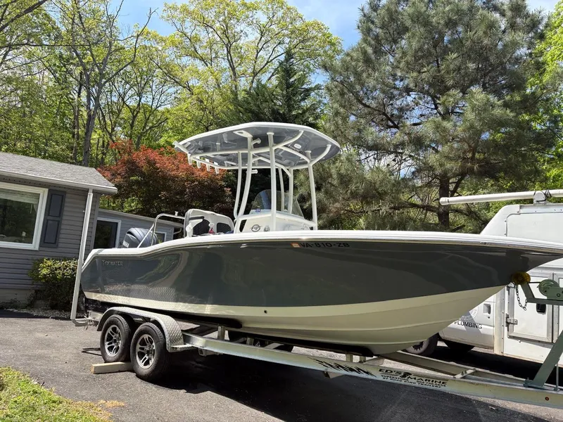 Slide: The Image of 2023 Tidewater 210 CC Adventure boat on trailer, parked in a driveway. - 0
