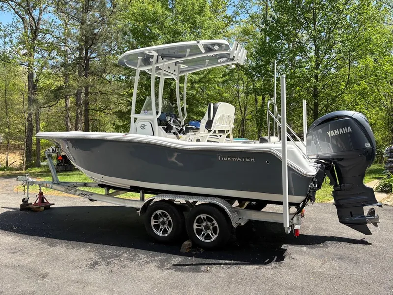 Slide: The Image of 2023 Tidewater 210 CC Adventure boat on trailer, parked outdoors with Yamaha engine. - 1