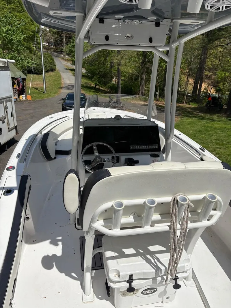 Slide: The Image of 2023 Tidewater 210 CC Adventure boat with center console and T-top, parked outdoors. - 4