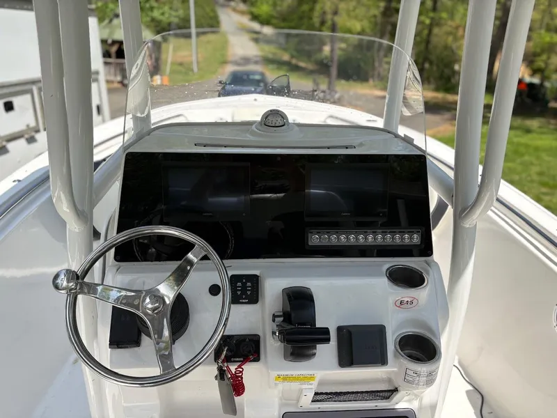 Slide: The Image of 2023 Tidewater 210 CC Adventure boat console with steering wheel and controls. - 5