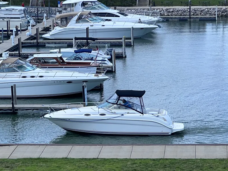 Slide: The Image of 2001 Sea Ray 260 Sundancer docked in a marina with other boats. - 1