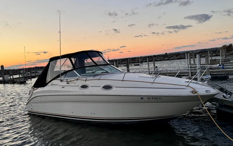 Slide: The Image of 2001 Sea Ray 260 Sundancer boat docked at sunset, calm waters, scenic marina. - 10