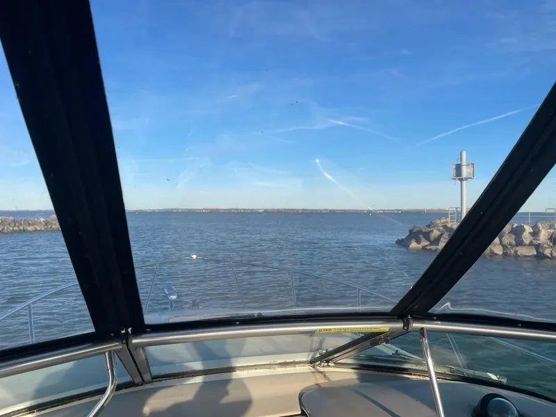Slide: The Image of View from a 2001 Sea Ray 260 Sundancer boat, overlooking calm waters and rocky shoreline. - 11