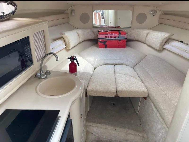 Slide: The Image of Interior of 2001 Sea Ray 260 Sundancer with kitchenette, seating, and life jackets. - 7