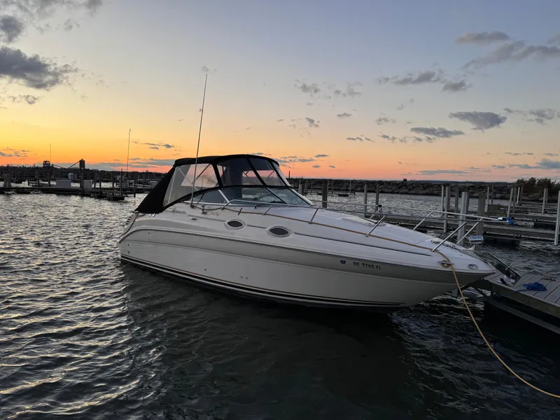 Slide: The Image of 2001 Sea Ray 260 Sundancer boat docked at sunset, calm waters, scenic marina view. - 9