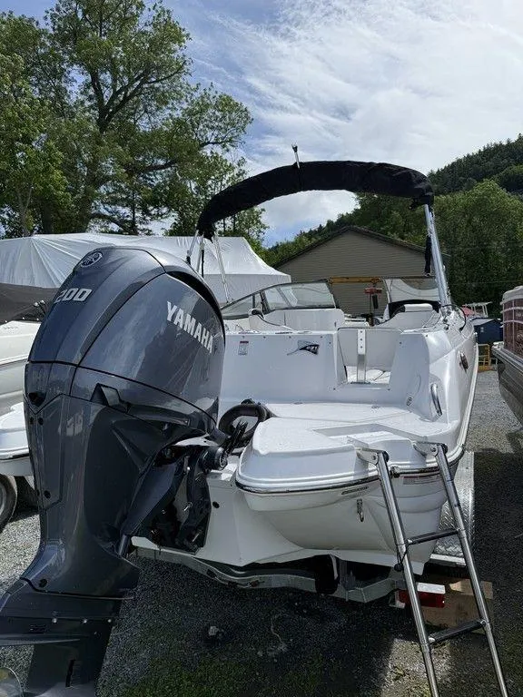 Slide: The Image of 2025 Stingray 231DC boat with Yamaha engine, parked outdoors under a cloudy sky. - 14