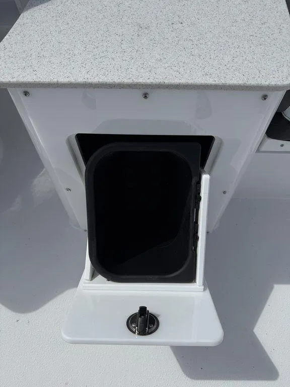 Slide: The Image of Open storage compartment on 2025 Stingray 231DC boat with a secure latch. - 15