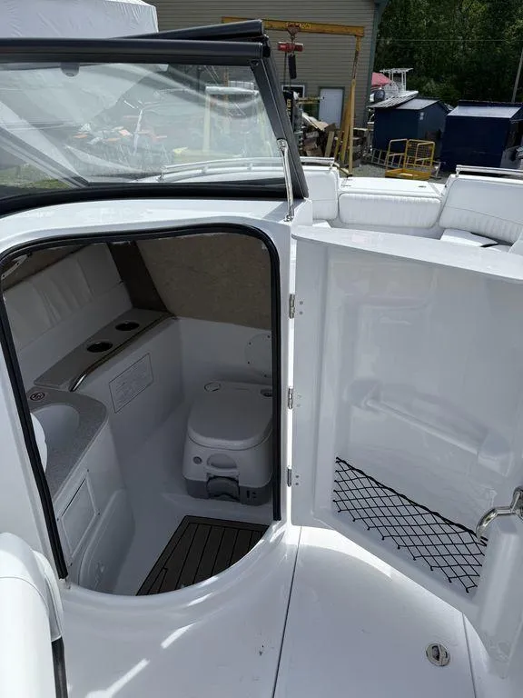 Slide: The Image of Interior view of 2025 Stingray 231DC boat's compact bathroom with toilet and sink. - 18