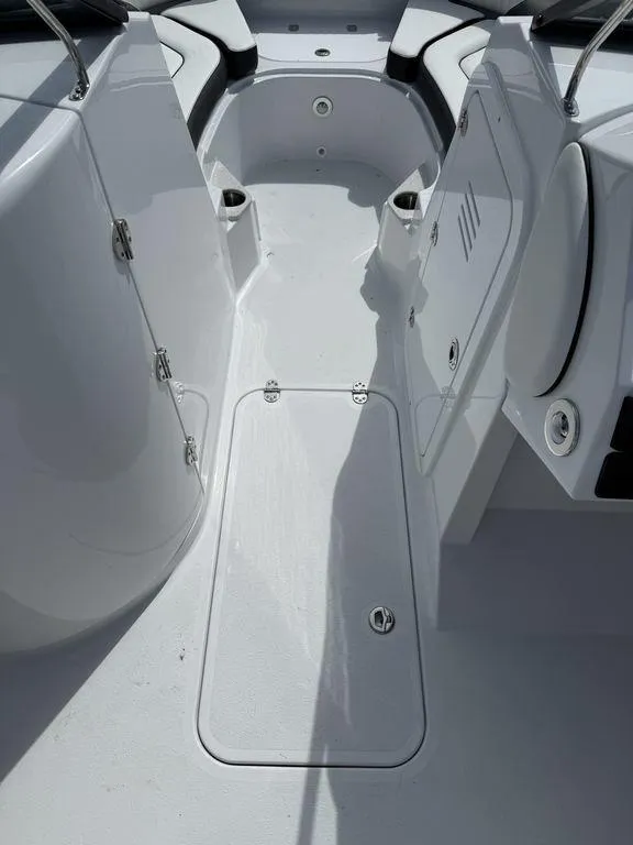 Slide: The Image of 2025 Stingray 231DC boat interior with white seating and storage compartments. - 19
