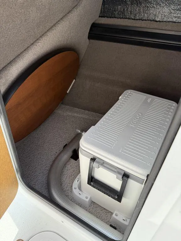 Slide: The Image of 2025 Stingray 231DC interior storage with cooler and wooden panel. - 20