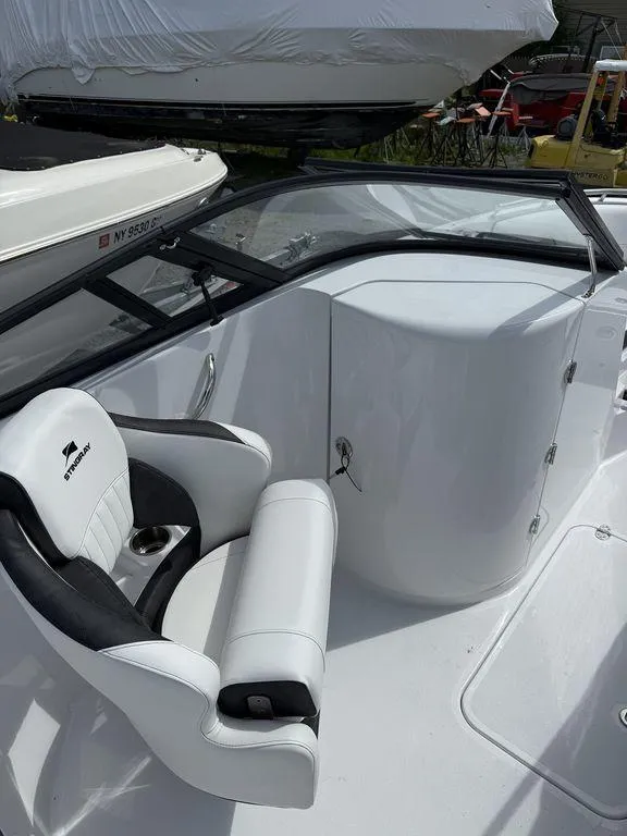Slide: The Image of 2025 Stingray 231DC boat interior with white seating and windshield. - 22