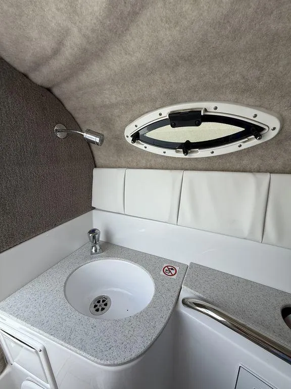 Slide: The Image of 2025 Stingray 231DC boat interior with sink and porthole window. - 23
