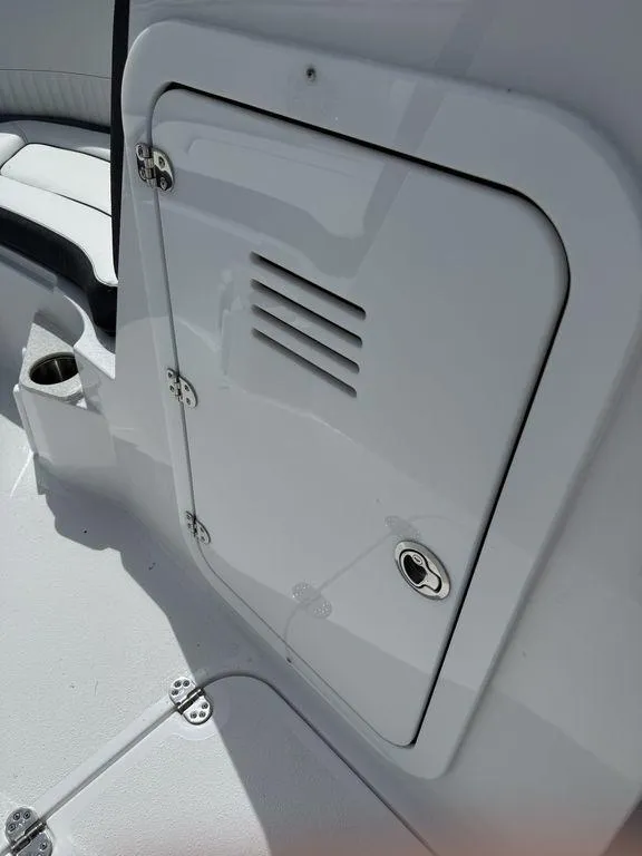 Slide: The Image of 2025 Stingray 231DC boat interior with storage compartment and cup holder. - 25