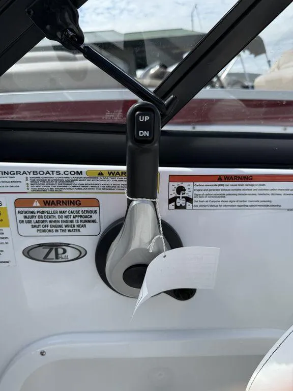 Slide: The Image of 2025 Stingray 231DC boat control panel with warning labels and trim switch. - 27