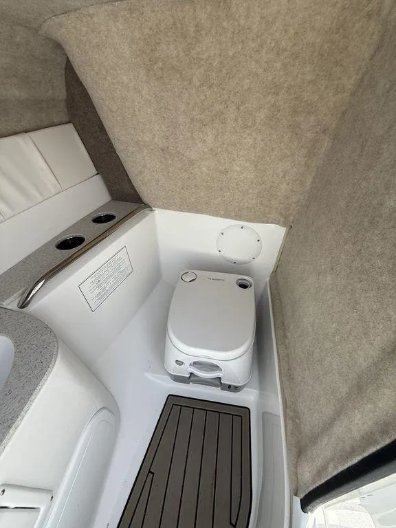 Slide: The Image of Interior of 2025 Stingray 231DC boat featuring a compact marine toilet. - 28