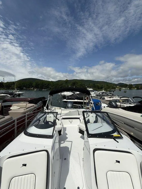 Slide: The Image of 2025 Stingray 231DC boat docked at marina, surrounded by scenic hills and blue sky. - 36