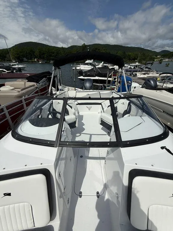 Slide: The Image of 2025 Stingray 231DC boat docked at a marina, surrounded by other boats. - 37