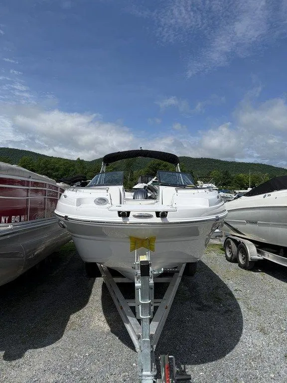 Slide: The Image of 2025 Stingray 231DC boat on trailer, parked outdoors under a partly cloudy sky. - 38