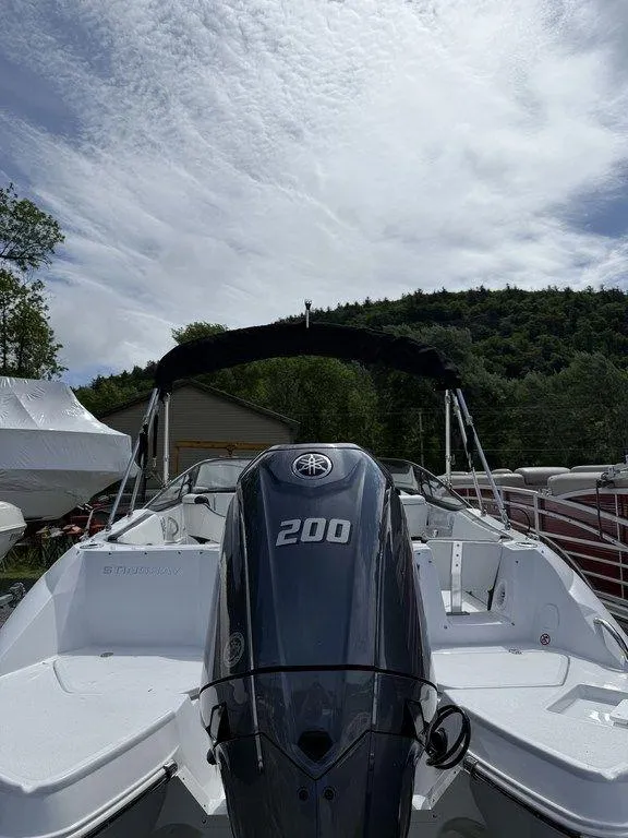 Slide: The Image of 2025 Stingray 231DC boat with Yamaha 200 engine, under a cloudy sky. - 4
