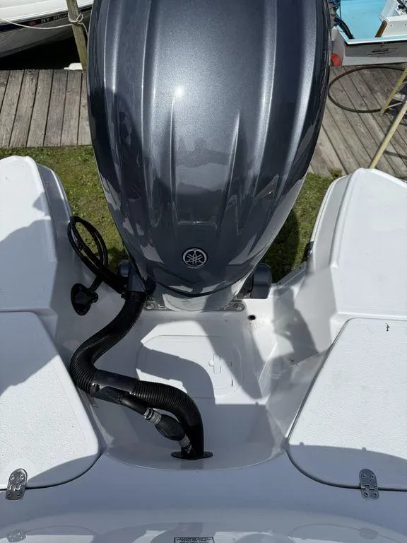 Slide: The Image of 2025 Stingray 231DC boat with Yamaha outboard motor, docked on wooden pier. - 7