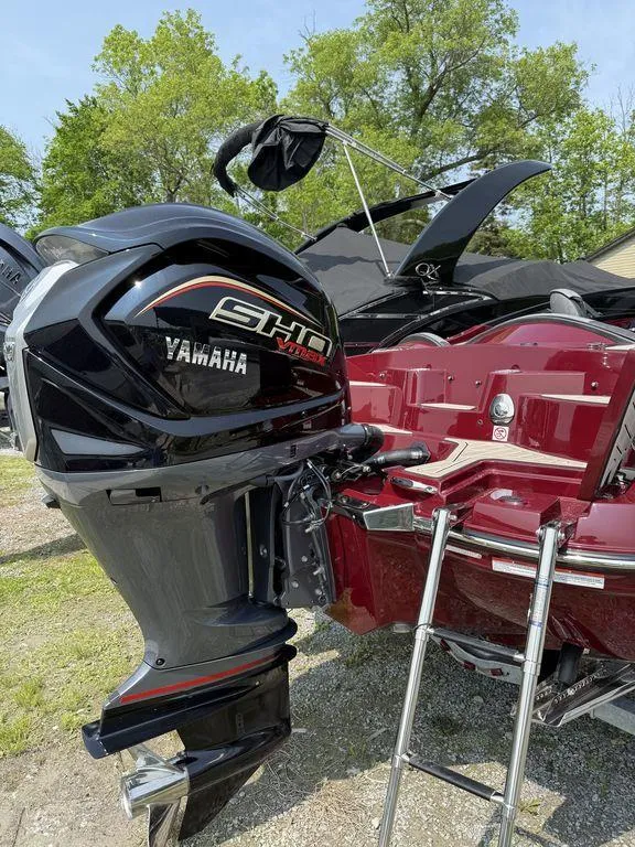 Slide: The Image of 2025 Stingray 23 OSX boat with Yamaha SHO outboard motor, parked outdoors. - 12