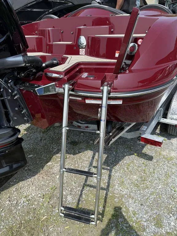Slide: The Image of 2025 Stingray 23 OSX boat with a chrome ladder and maroon exterior. - 13