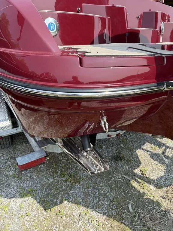 Slide: The Image of 2025 Stingray 23 OSX boat, maroon hull, on trailer, rear view. - 14