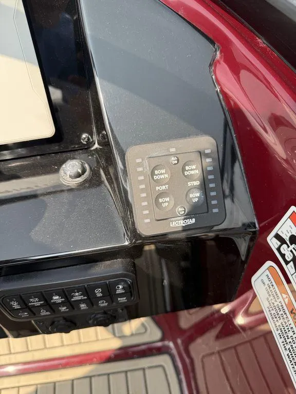 Slide: The Image of Control panel of 2025 Stingray 23 OSX boat with trim tab switches. - 18