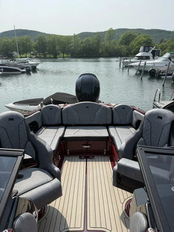 Slide: The Image of 2025 Stingray 23 OSX boat with luxurious seating, docked in a scenic marina. - 19