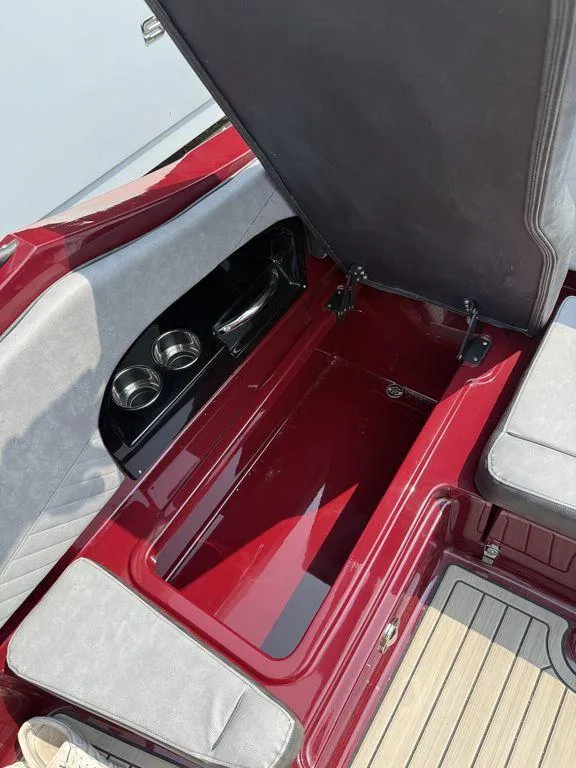 Slide: The Image of 2025 Stingray 23 OSX boat interior with open storage compartment and cup holders. - 28