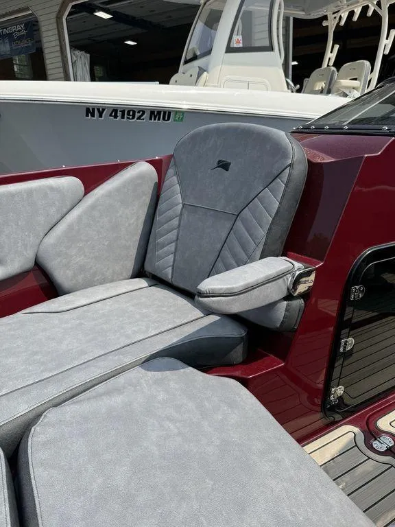 Slide: The Image of 2025 Stingray 23 OSX boat with luxurious gray seating and sleek red interior design. - 29