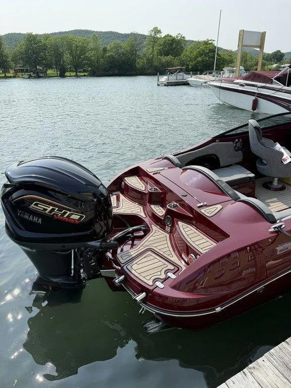 Slide: The Image of 2025 Stingray 23 OSX boat with Yamaha engine docked on a serene lake. - 8