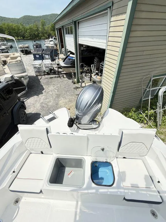 Slide: The Image of 2025 Stingray 216CC boat with outboard motor, docked near a storage facility. - 14