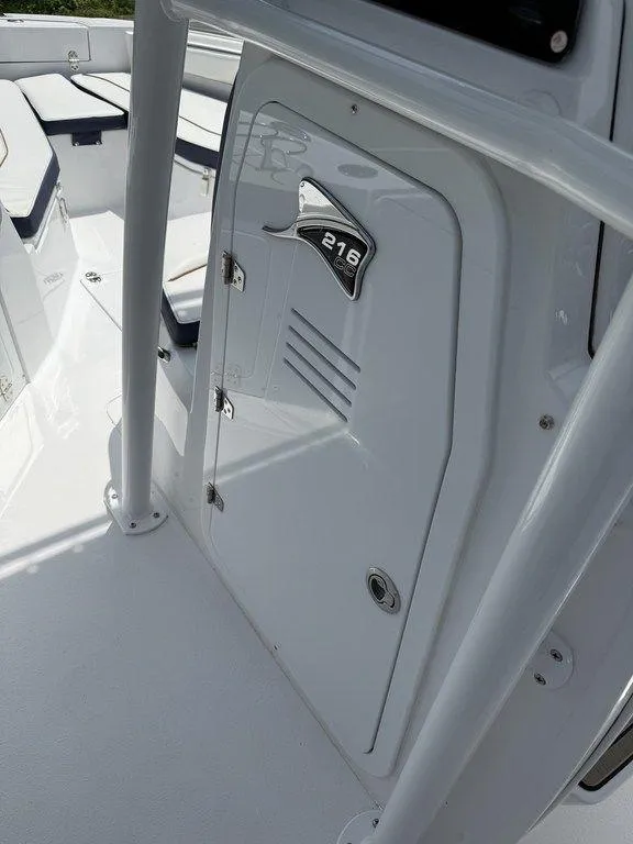 Slide: The Image of 2025 Stingray 216CC boat interior, featuring sleek white design and storage compartment. - 15