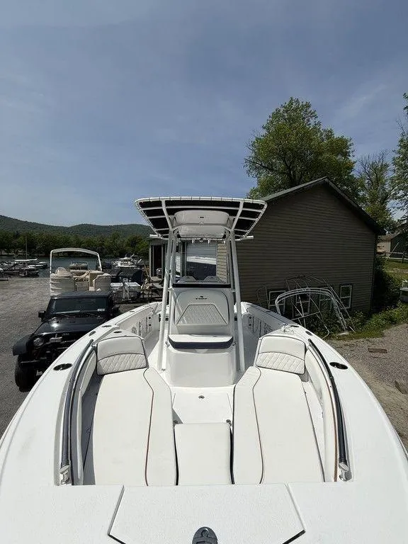 Slide: The Image of 2025 Stingray 216CC boat with sleek design, docked outdoors under clear sky. - 19