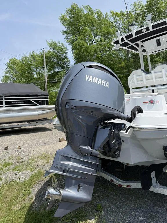 Slide: The Image of 2025 Stingray 216CC boat with Yamaha outboard motor, parked outdoors. - 3