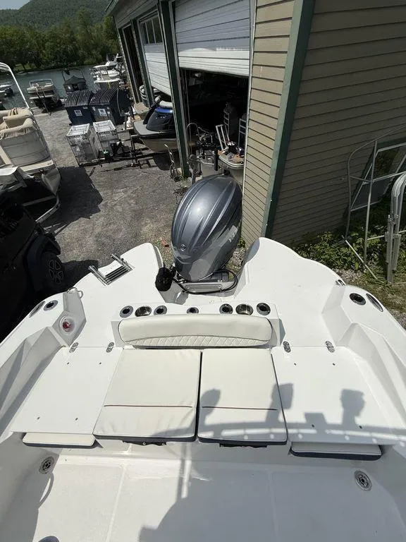 Slide: The Image of 2025 Stingray 216CC boat with outboard motor, docked near storage facility. - 5