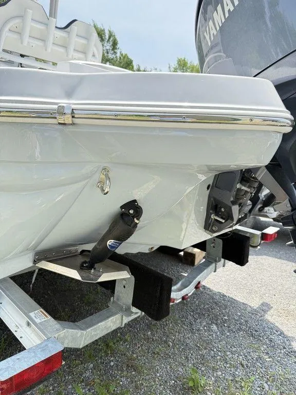 Slide: The Image of 2025 Stingray 216CC boat on trailer, rear view with motor and trim tabs visible. - 7