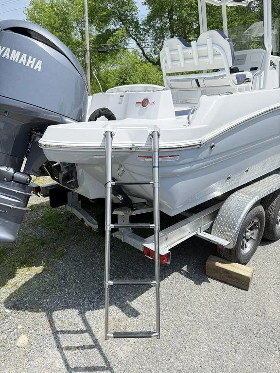 Slide: The Image of 2025 Stingray 216CC boat with Yamaha engine on trailer, featuring rear ladder. - 9