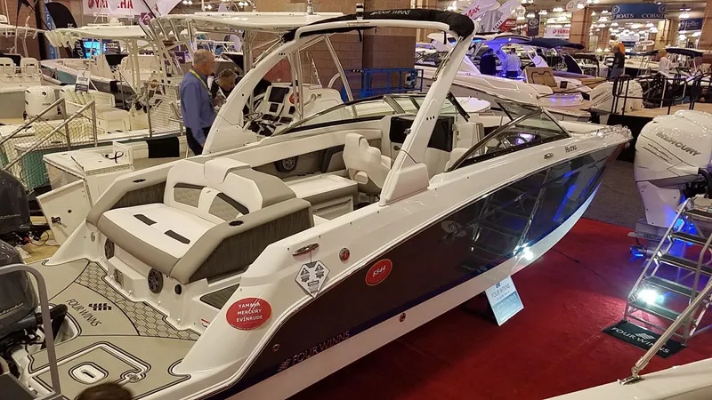Slide: The Image of 2018 Four Winns HD270 OB boat displayed at an indoor boat show. - 11