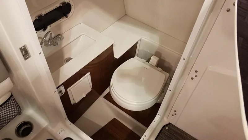 Slide: The Image of 2018 Four Winns HD270 OB boat interior with compact bathroom and toilet. - 13