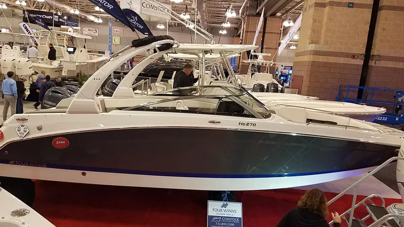 Slide: The Image of 2018 Four Winns HD270 OB boat displayed at an indoor boat show. - 4